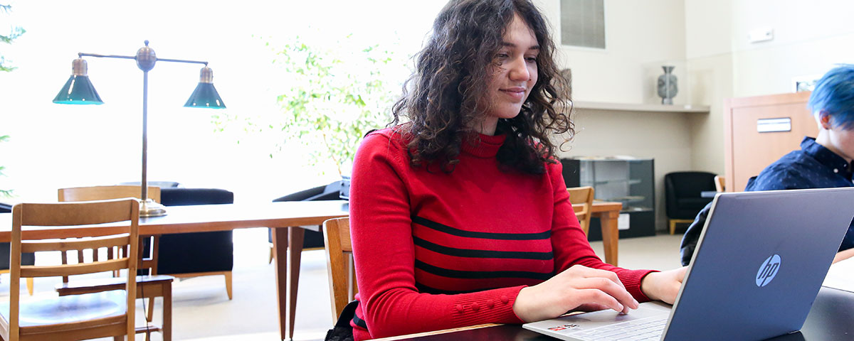 Student working on laptop in Cole Library'