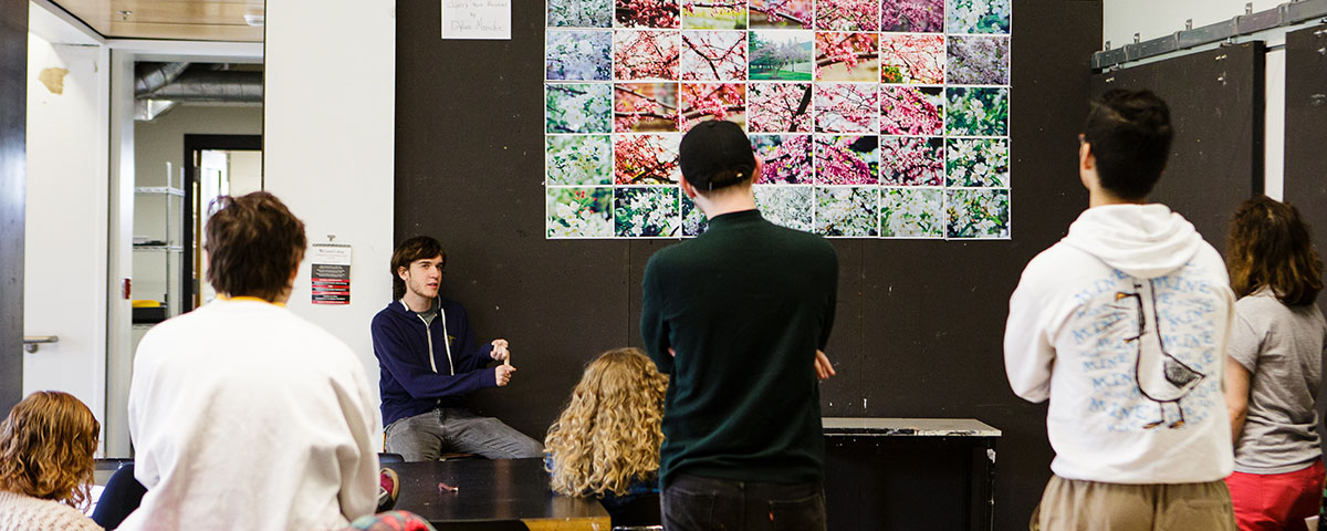 Students presenting in art classroom.