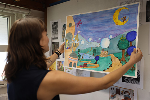 Student examines an art illustration she has created