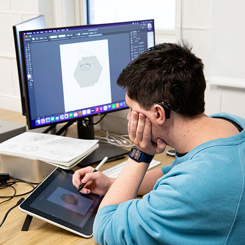Students drawing on a tablet connected to a Mac in the digital arts lab in McWethy Hall