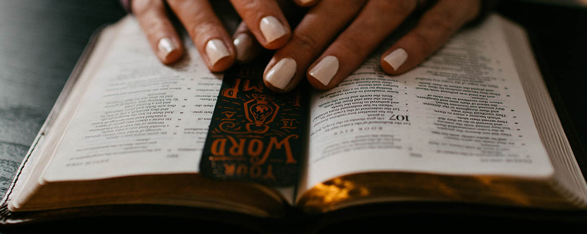 Hands on Bible. Photo by Kelly Sikkema on Unsplash
