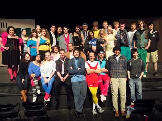 The cast and crew of the 2011 production of Plautus's Asinaria pose for a group photo on the stage. It's a somewhat large group