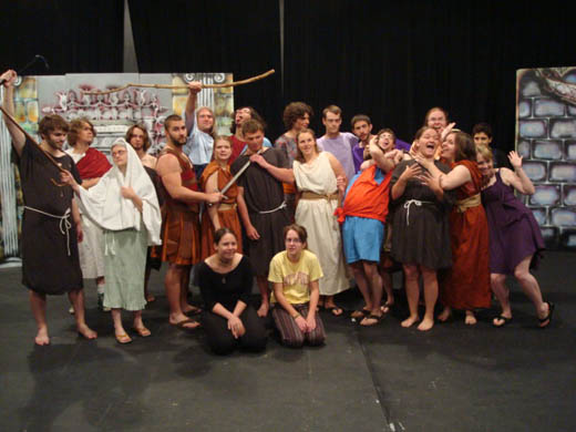 The cast of the 2009 production of Eunuch pose for a group photo on the set of the play. they are dressed in their costume for the play and some seem to be acting as the characters they play.