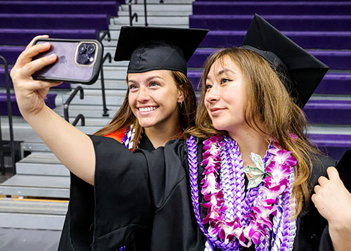 Two new cornell graduates taking a photo before the 2024 ceremony.