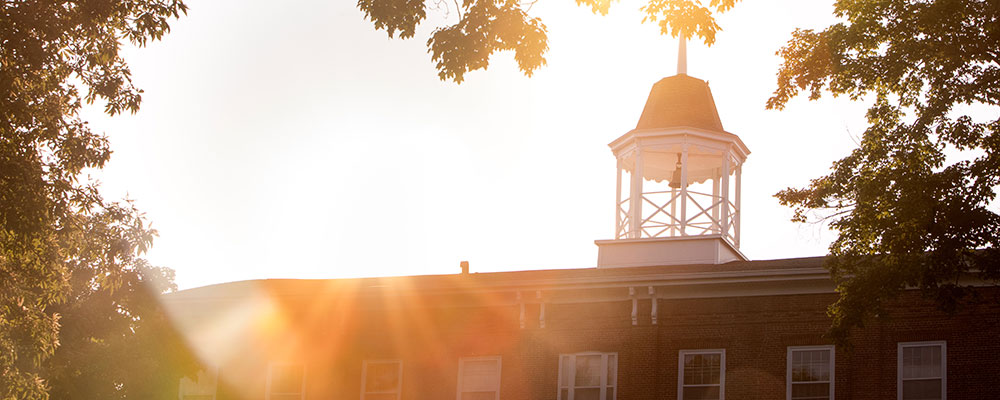 College Hall with the sun setting behind it. 