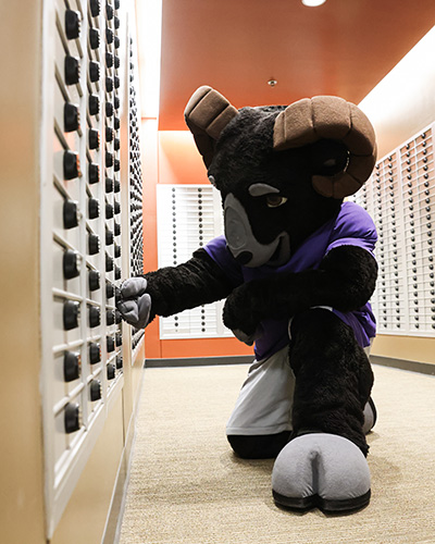 College mascot opening a student mailbox in Thomas Commons