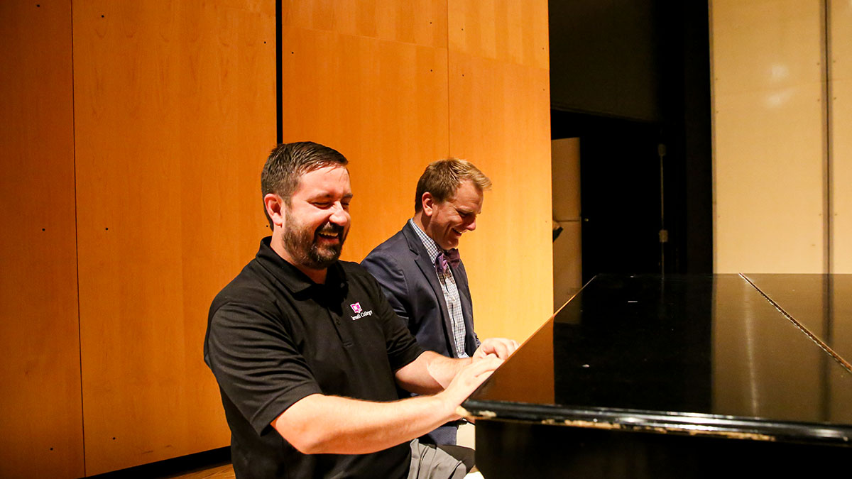 Music faculty goofing around at grand piano