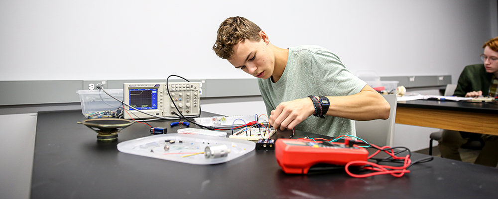 One Course Summer Institute student in an electronics lab hands-on learning