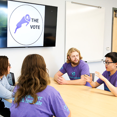 Students and professor working on research project about voting in US elections.